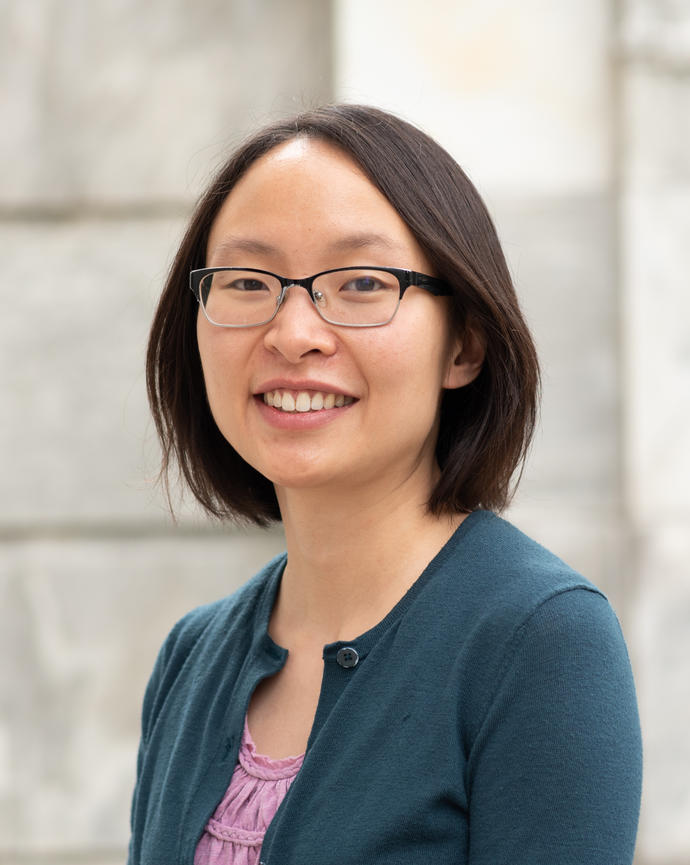 Professor Song headshot photo of her smiling wearing glasses, a teal cardigan, and pink undershirt; sporting medium length brown hair