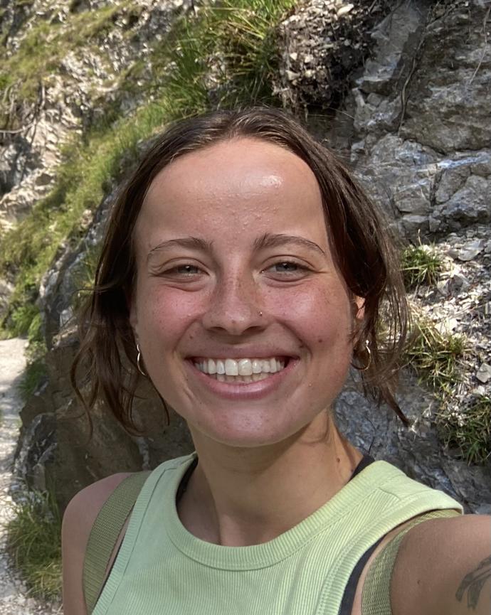 profile picture of Lily Fornof smiling in front of a boulder covered in grasses